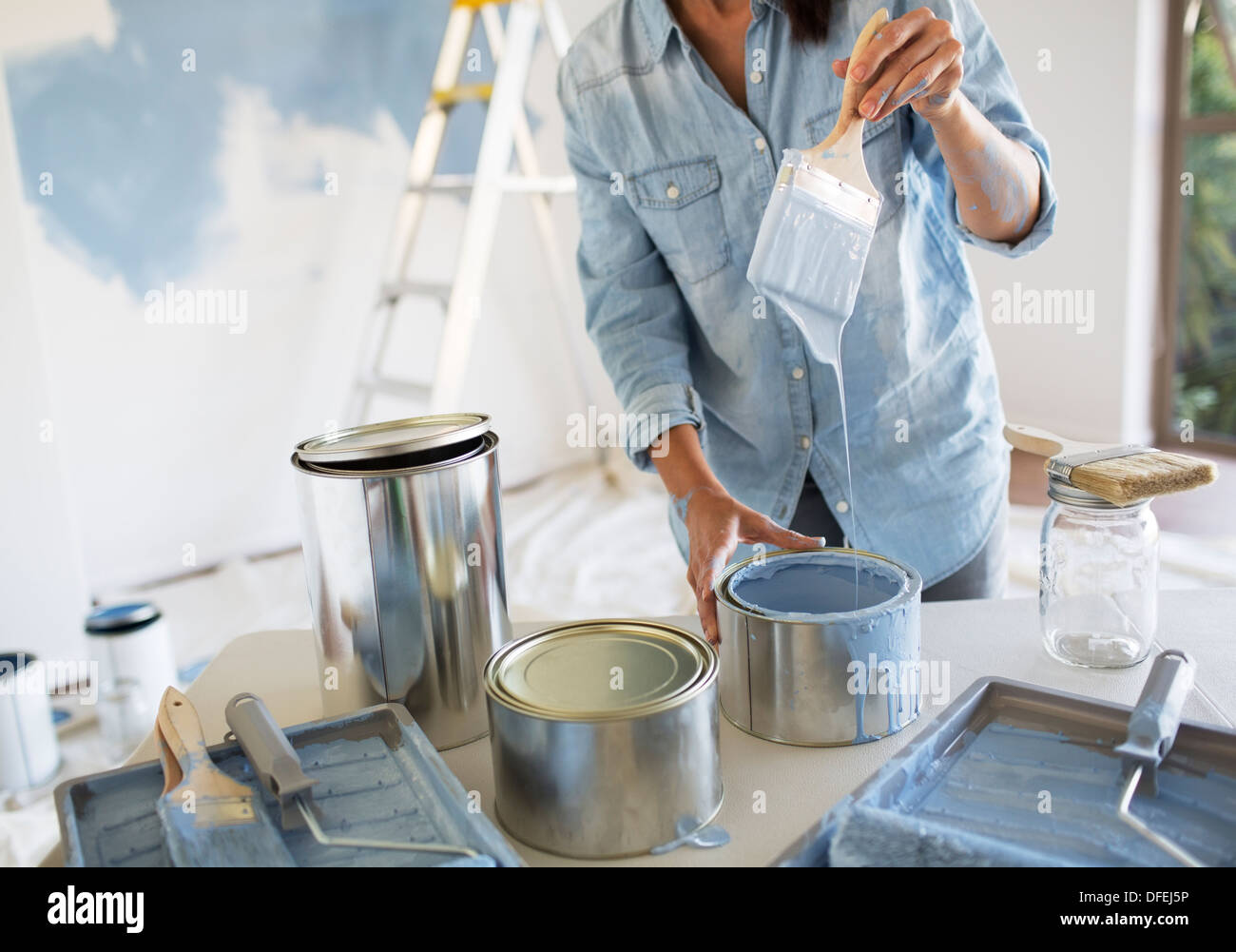 Woman holding paintbrush with blue paint Stock Photo
