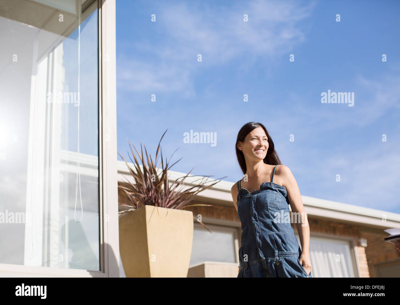 Woman walking outside modern house Stock Photo