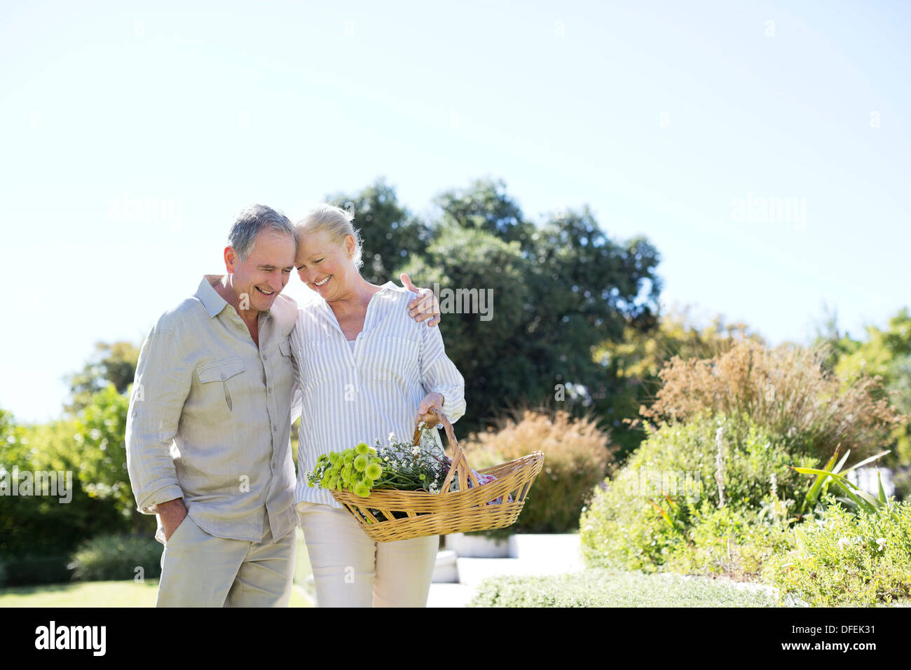 Senior couple walking with basket outdoors Stock Photo