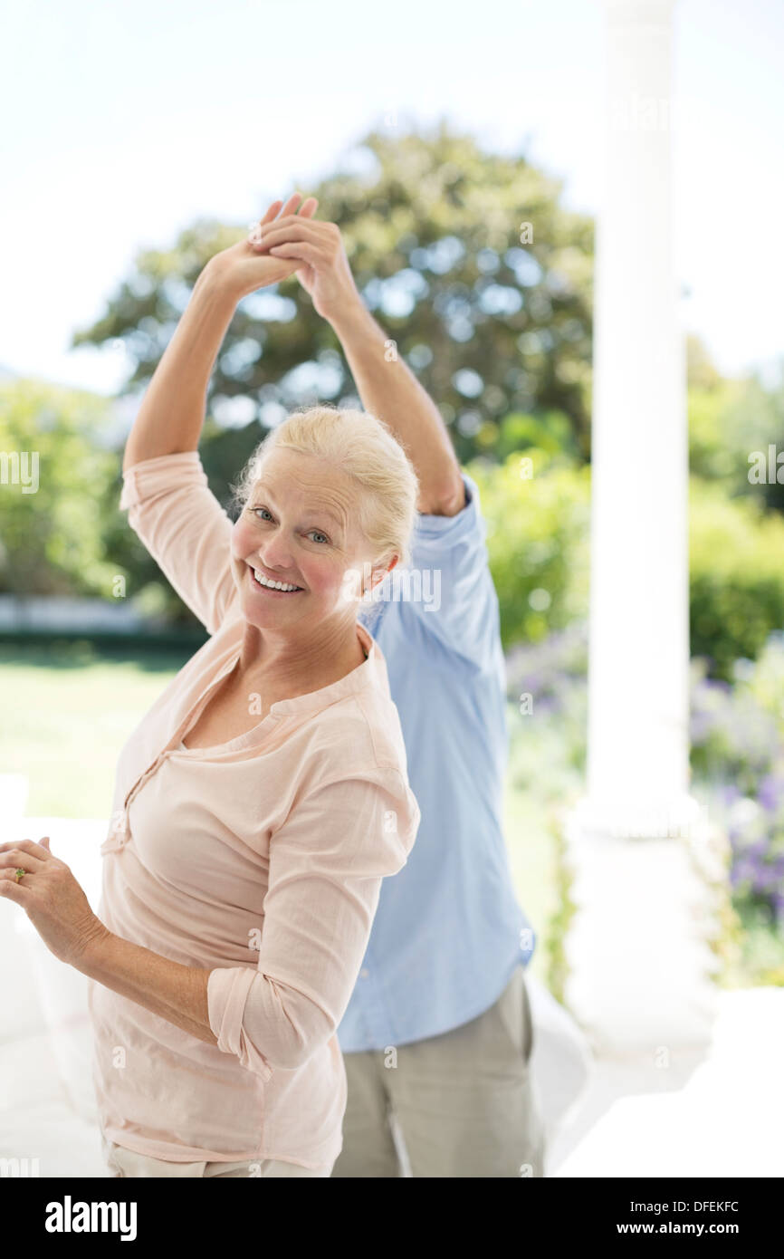 Senior couple dancing on patio Stock Photo