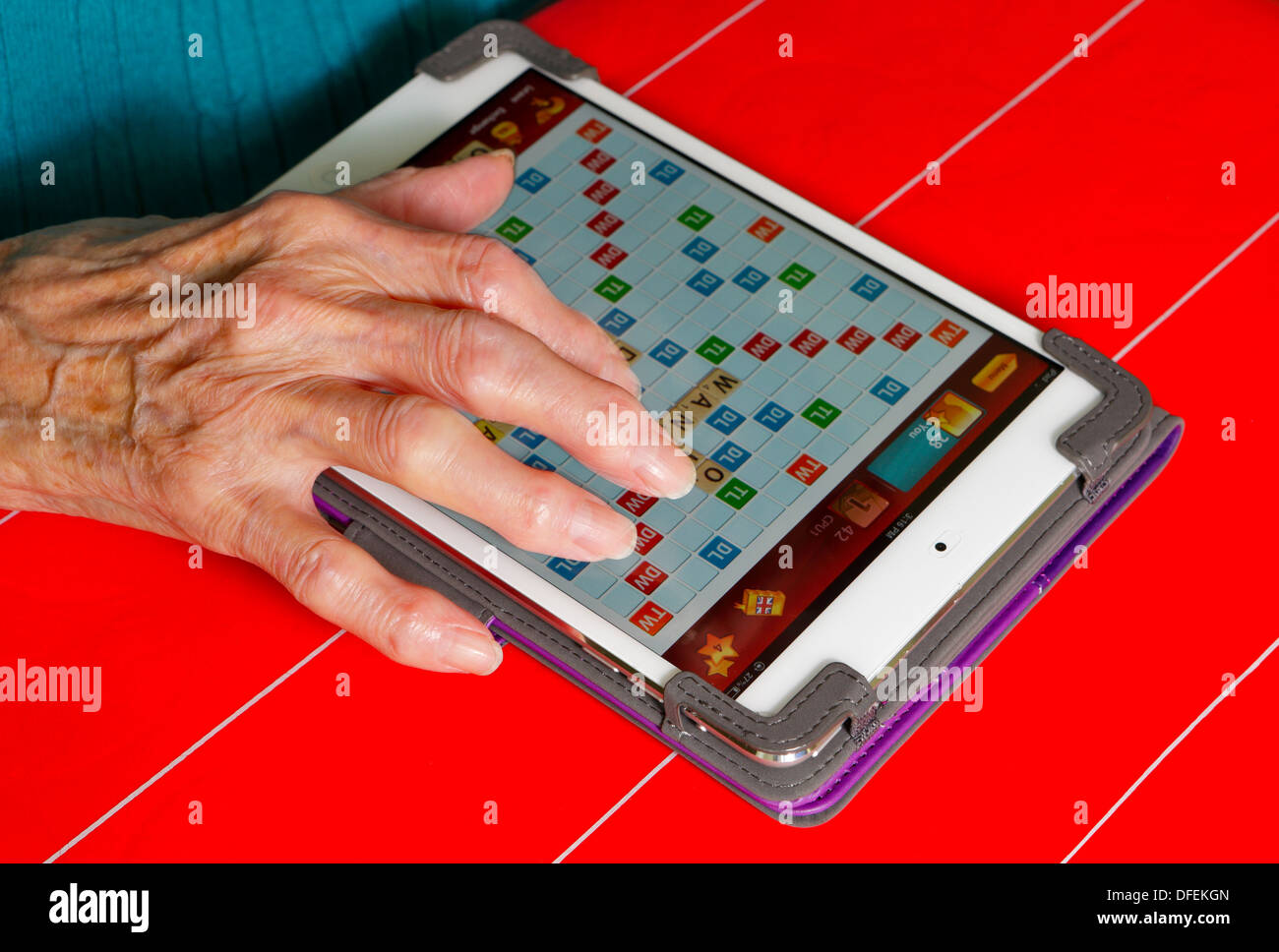Elderly lady playing Scrabble word game on Apple Minipad-Victoria, British Columbia, Canada. Stock Photo