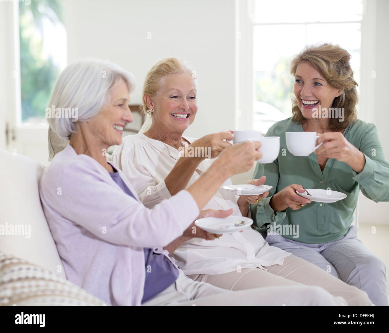 Senior women toasting coffee cups Stock Photo