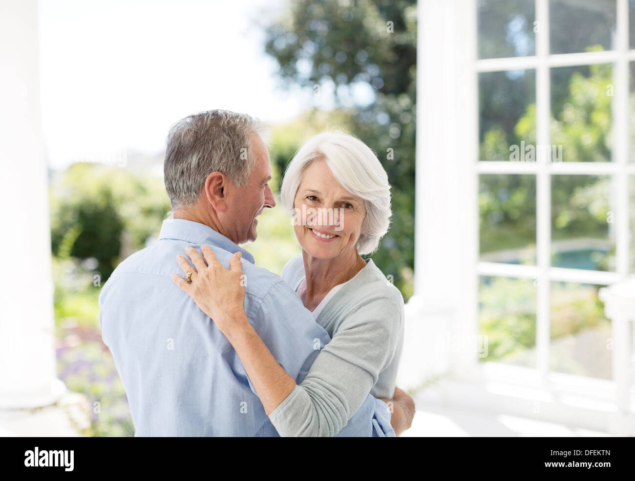 Senior couple dancing on patio Stock Photo