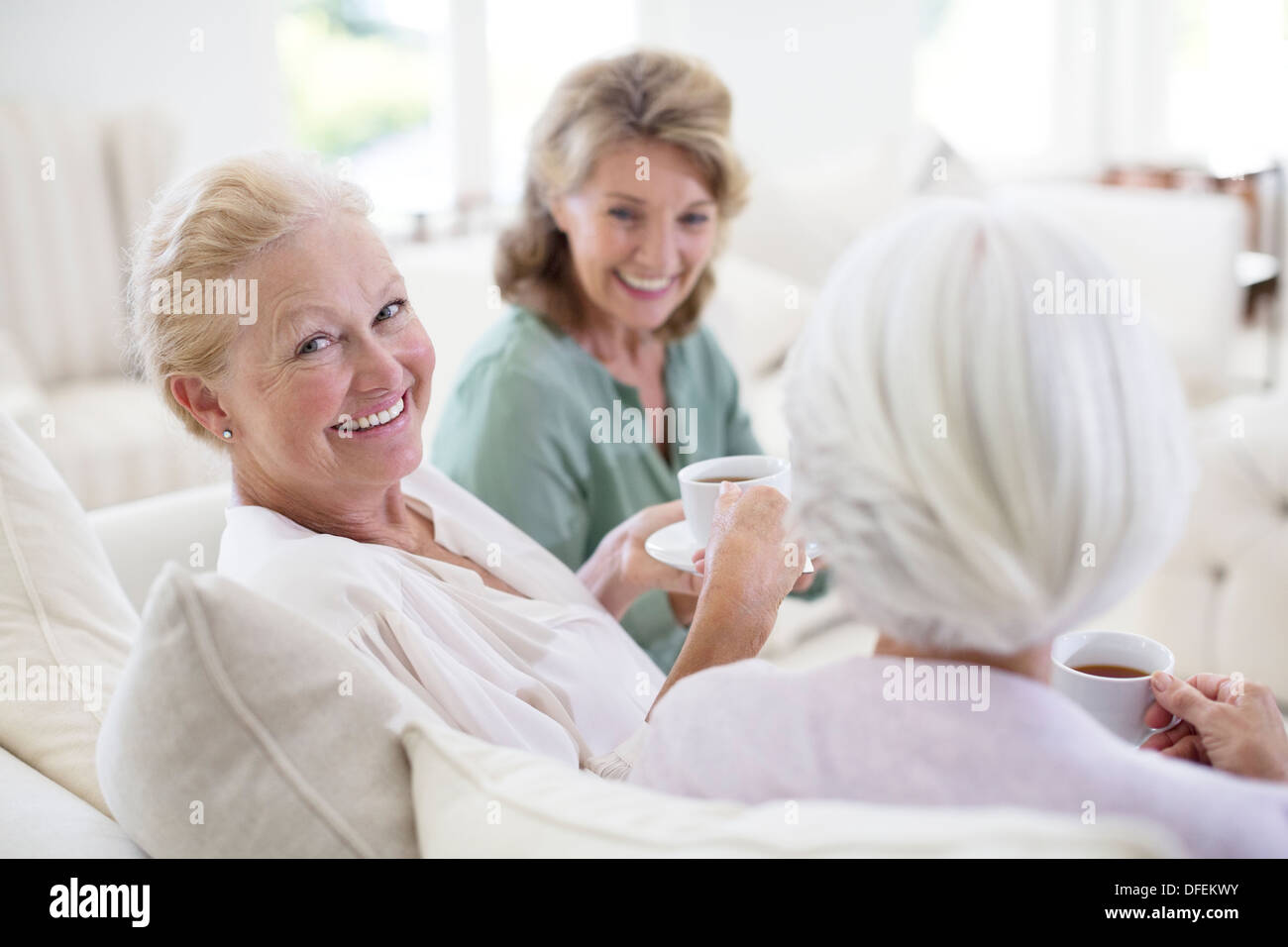 Senior women drinking coffee on sofa Stock Photo