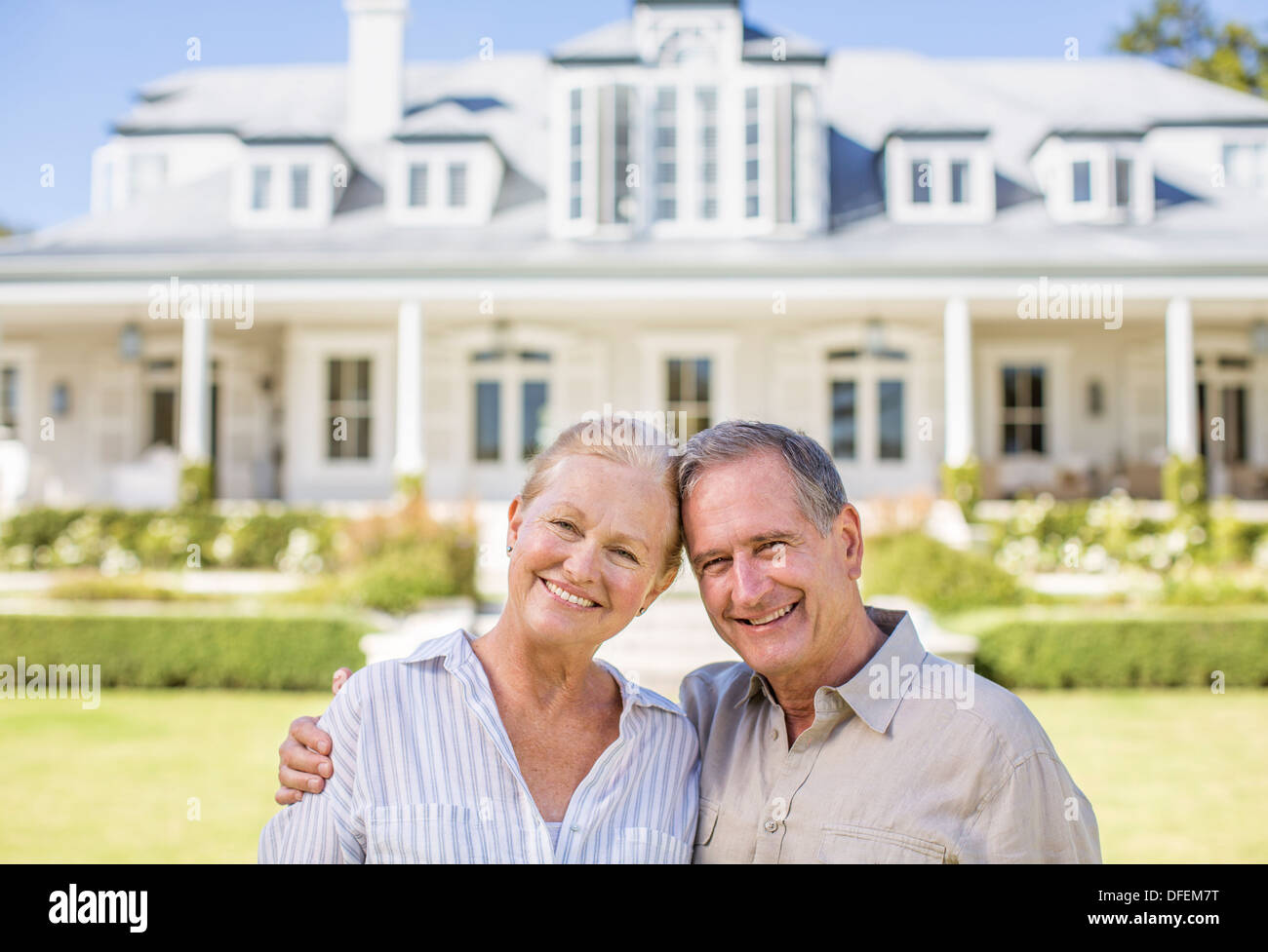 Portrait of smiling senior couple in front of house Stock Photo