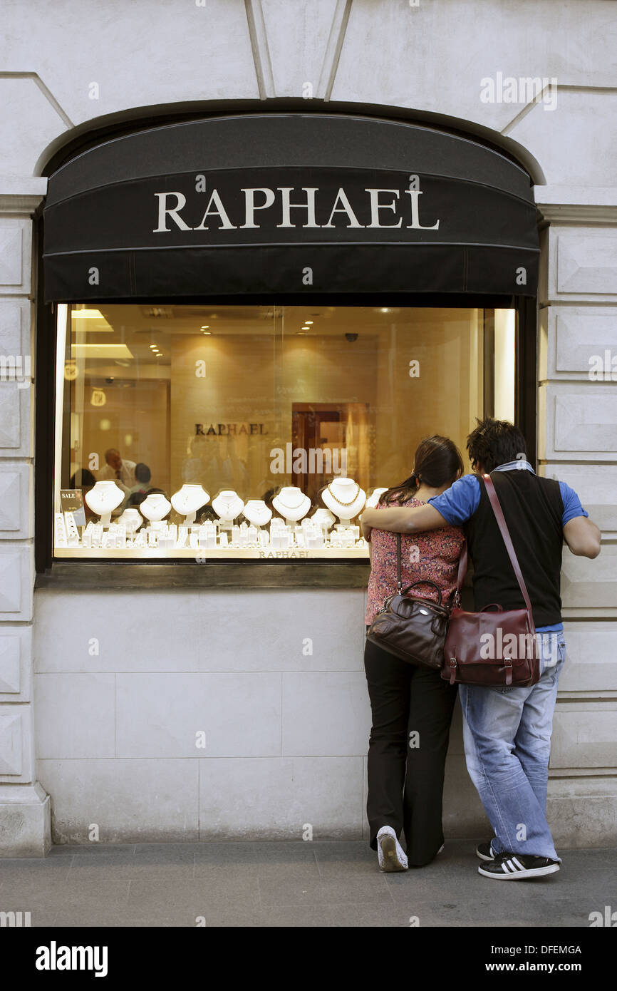 Young Asian couple standing in front of a jewellry shop selling