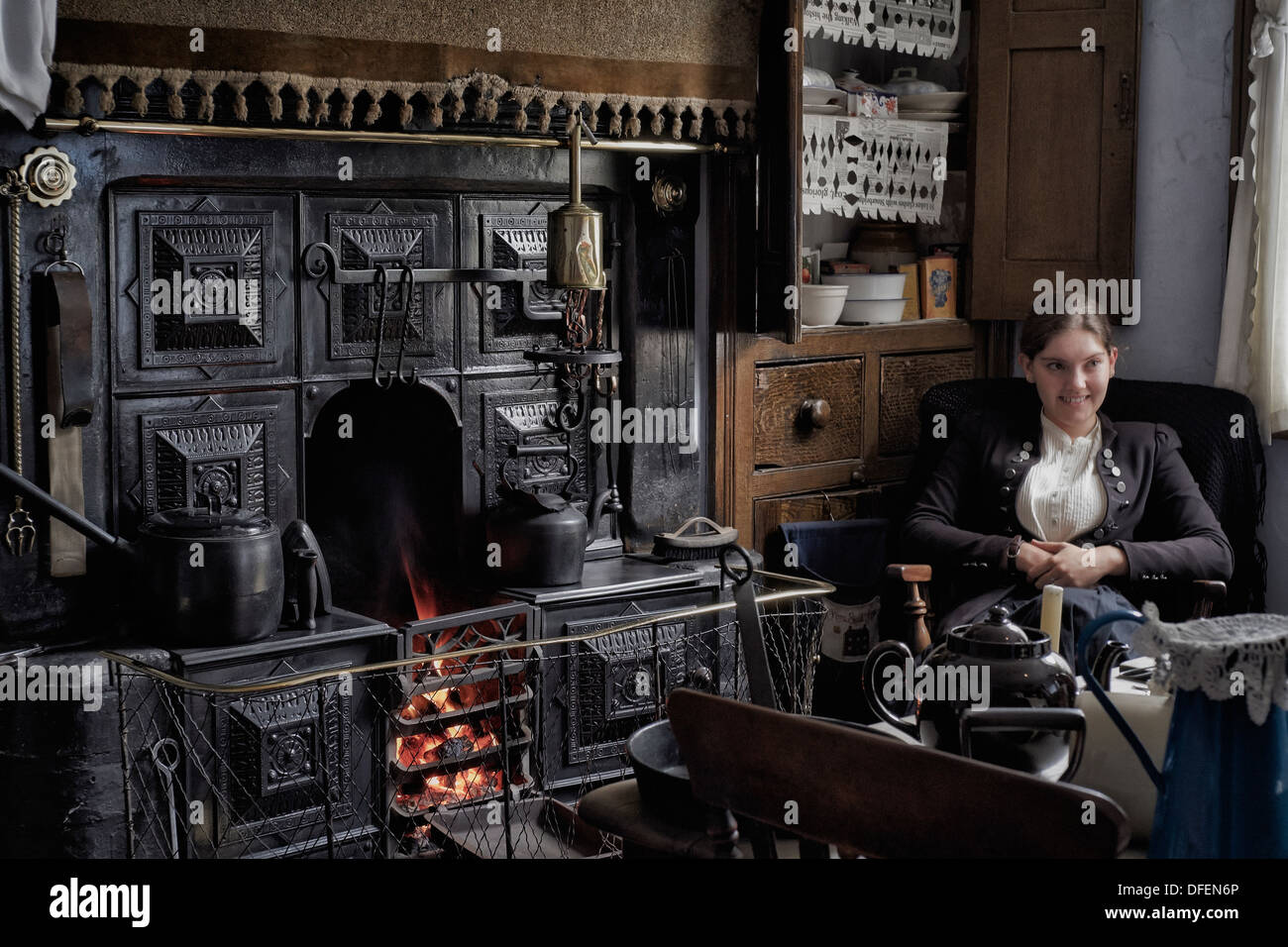 Black Country Living Museum. Female employee welcoming visitors in a preserved 1800's/early 1900's cottage type home. Victorian era room England UK Stock Photo
