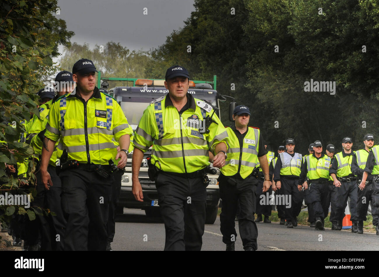 Police officers outnumber protesters as another lorry is escorted to Cuadrilla test drilling site outside the Sussex village. Stock Photo