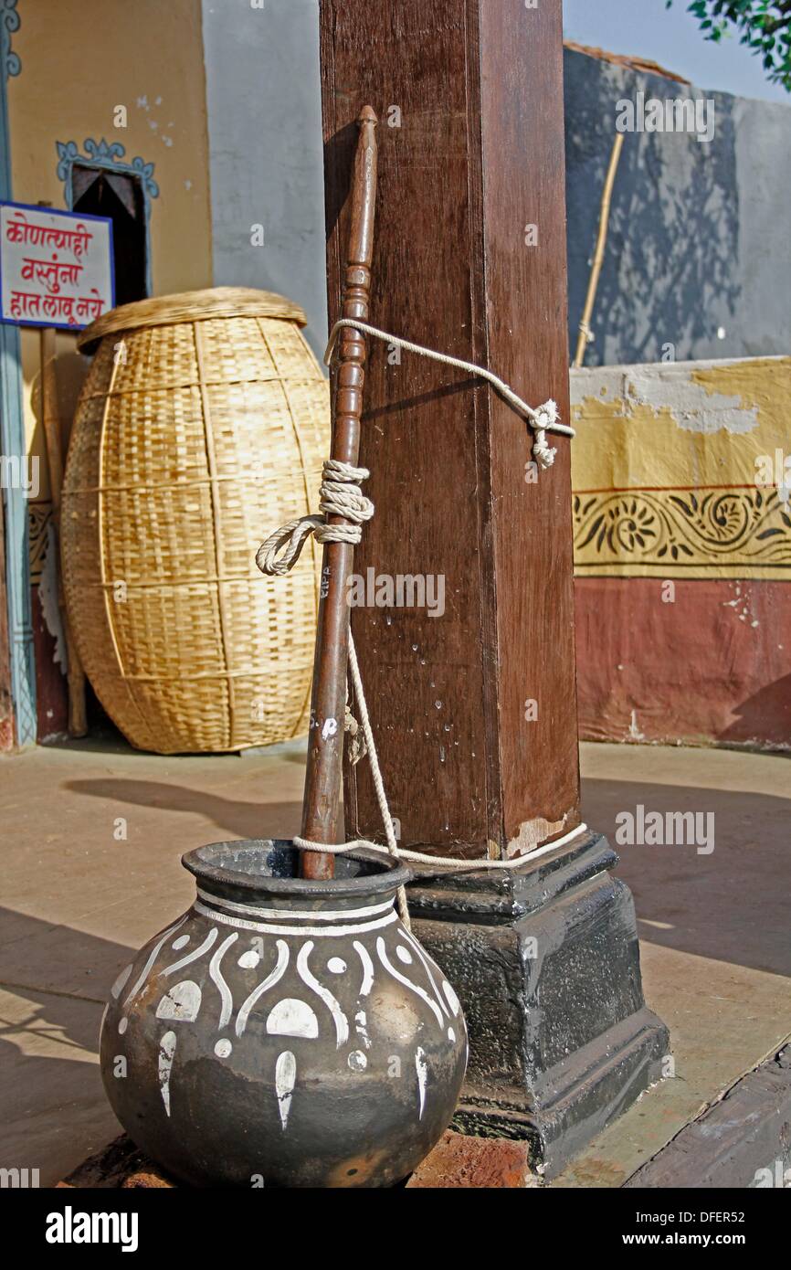 A traditional Indian butter churn is operated by the pulling the rope