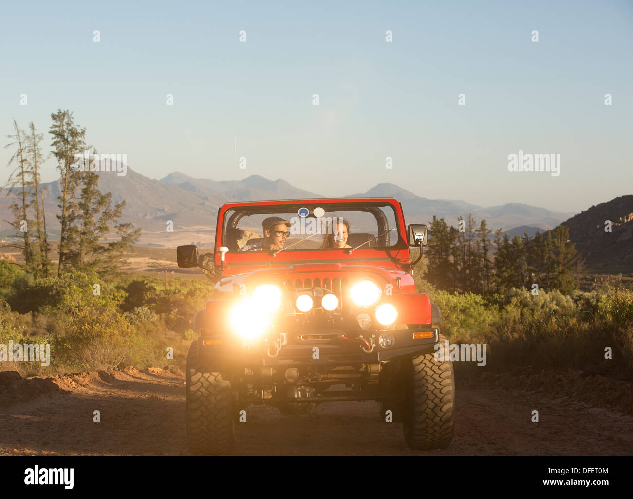 Couple driving sport utility vehicle on dirt road Stock Photo