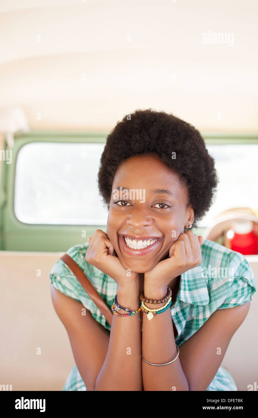Portrait of smiling woman in back seat of camper van Stock Photo