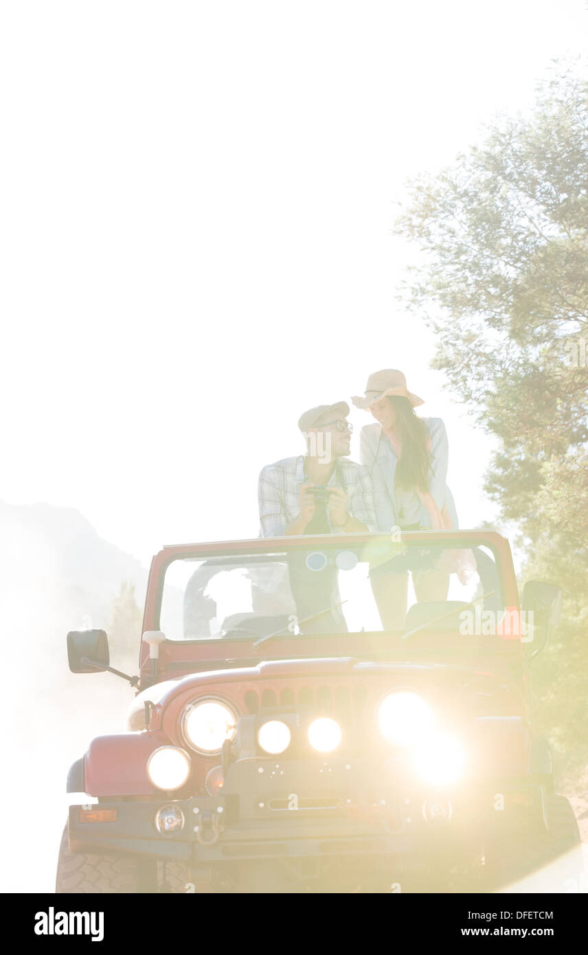 Couple standing in sport utility vehicle Stock Photo