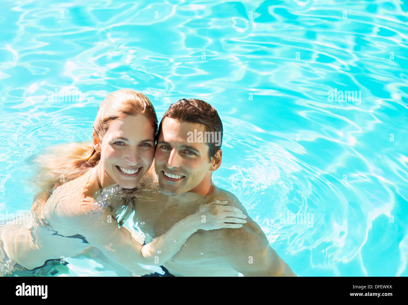 Portrait of smiling couple in swimming pool Stock Photo Alamy