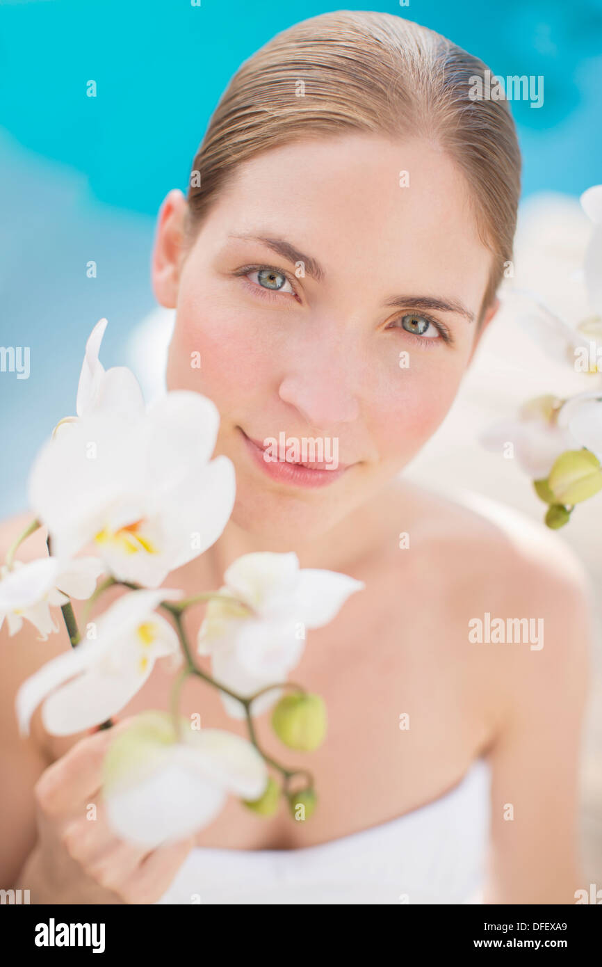 Woman holding flower poolside Stock Photo