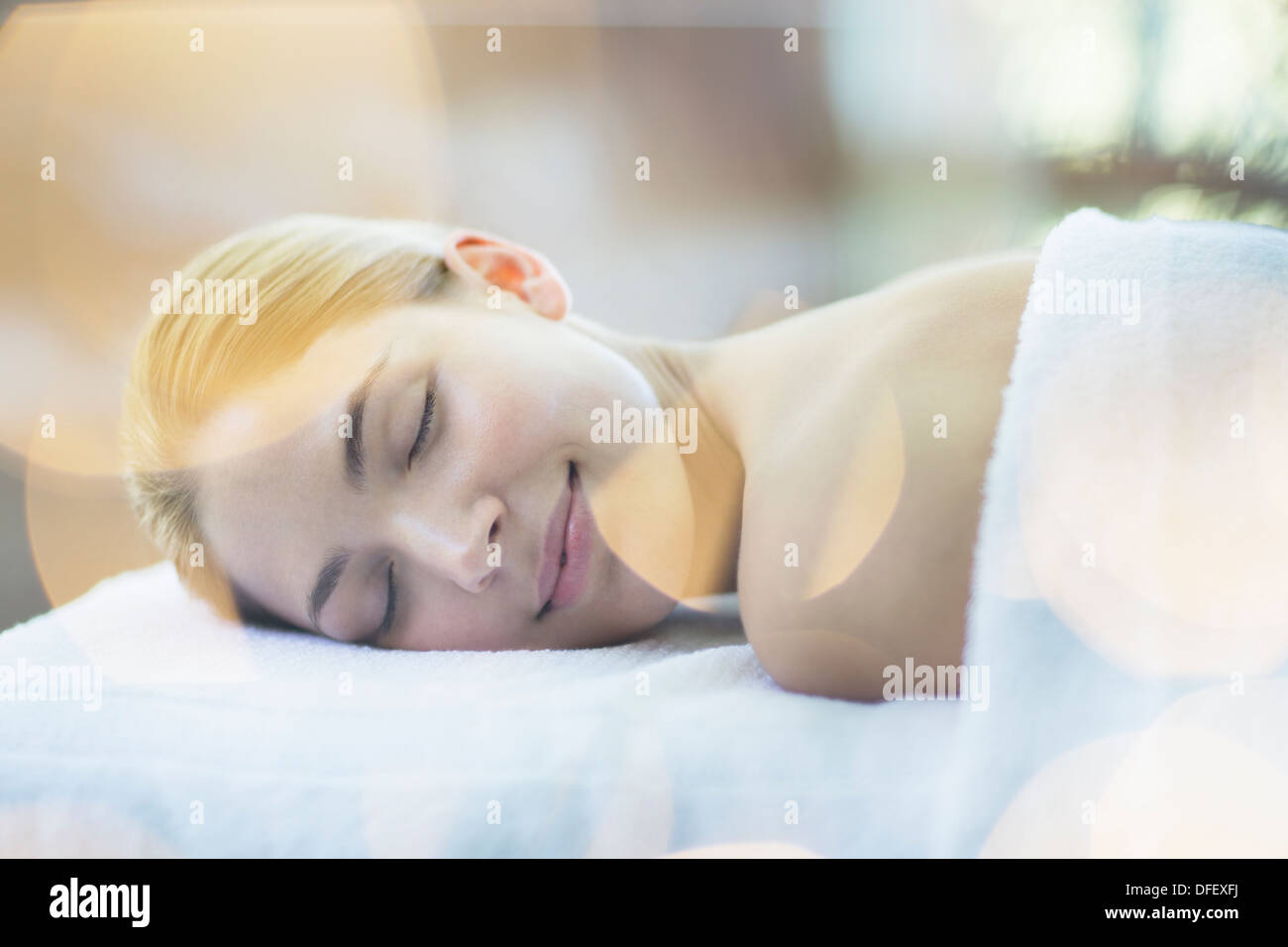 Woman laying on massage table in spa Stock Photo