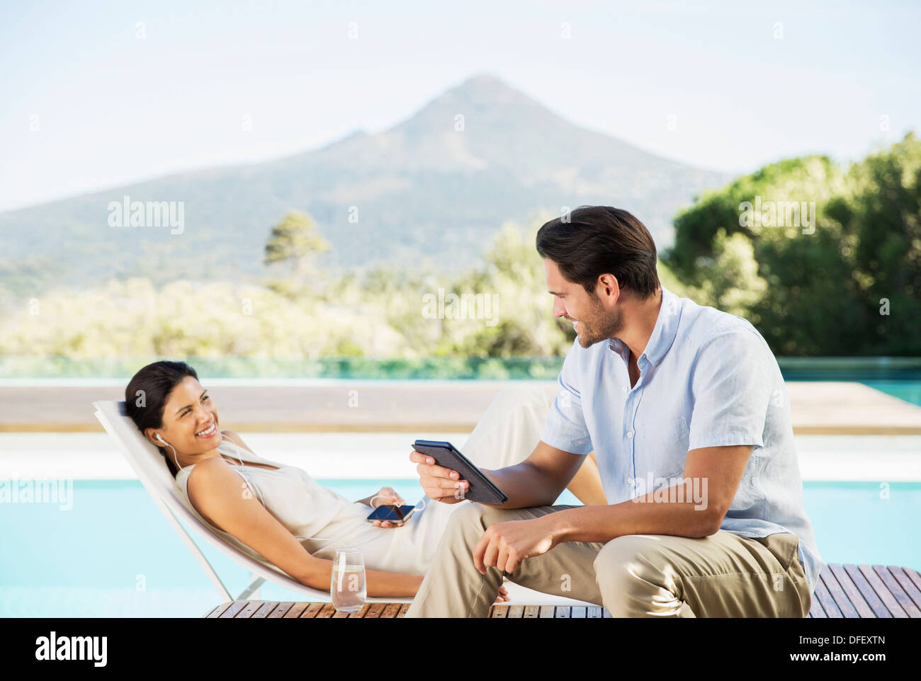 Couple relaxing poolside Stock Photo