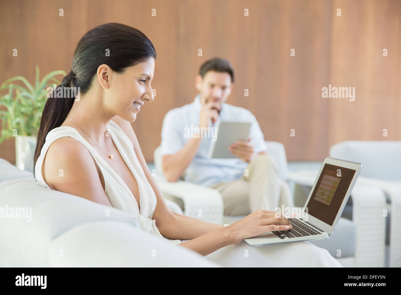 Woman using laptop on sofa Stock Photo