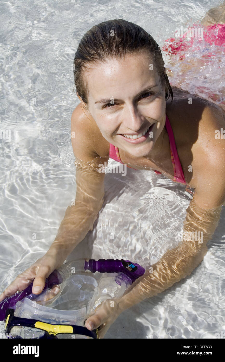 Woman lying in shallow water, holding a snorkel. Fraser Island