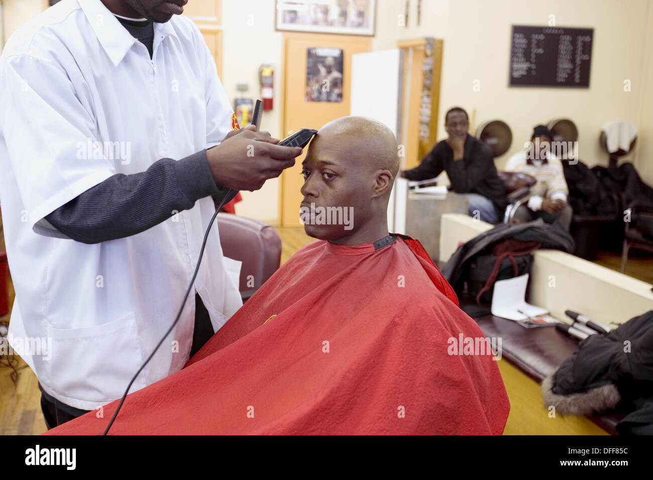 USA. New York City, Harlem. Man getting head shaved at barber shop