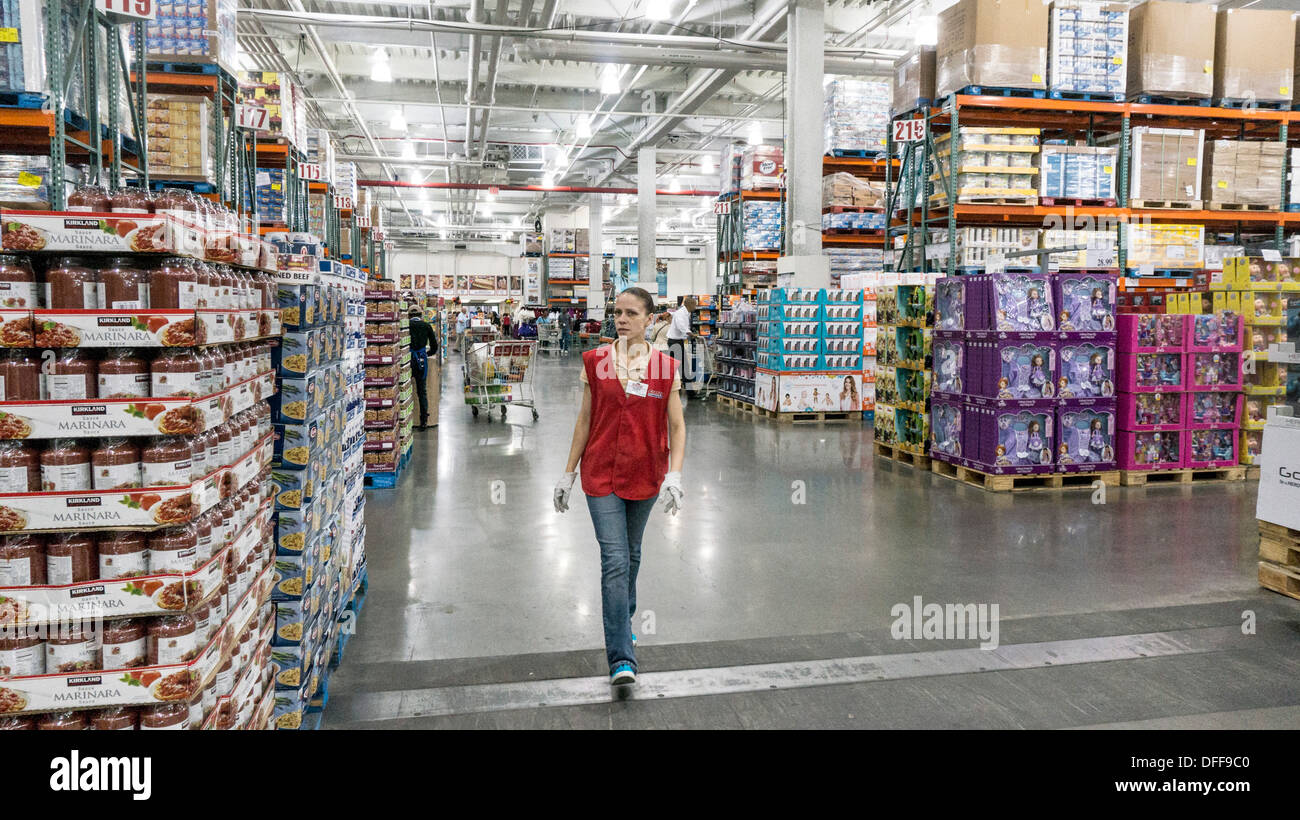 broad main aisle separates lateral aisles with grocery items on one side & household items on the other in Costco warehouse NYC Stock Photo