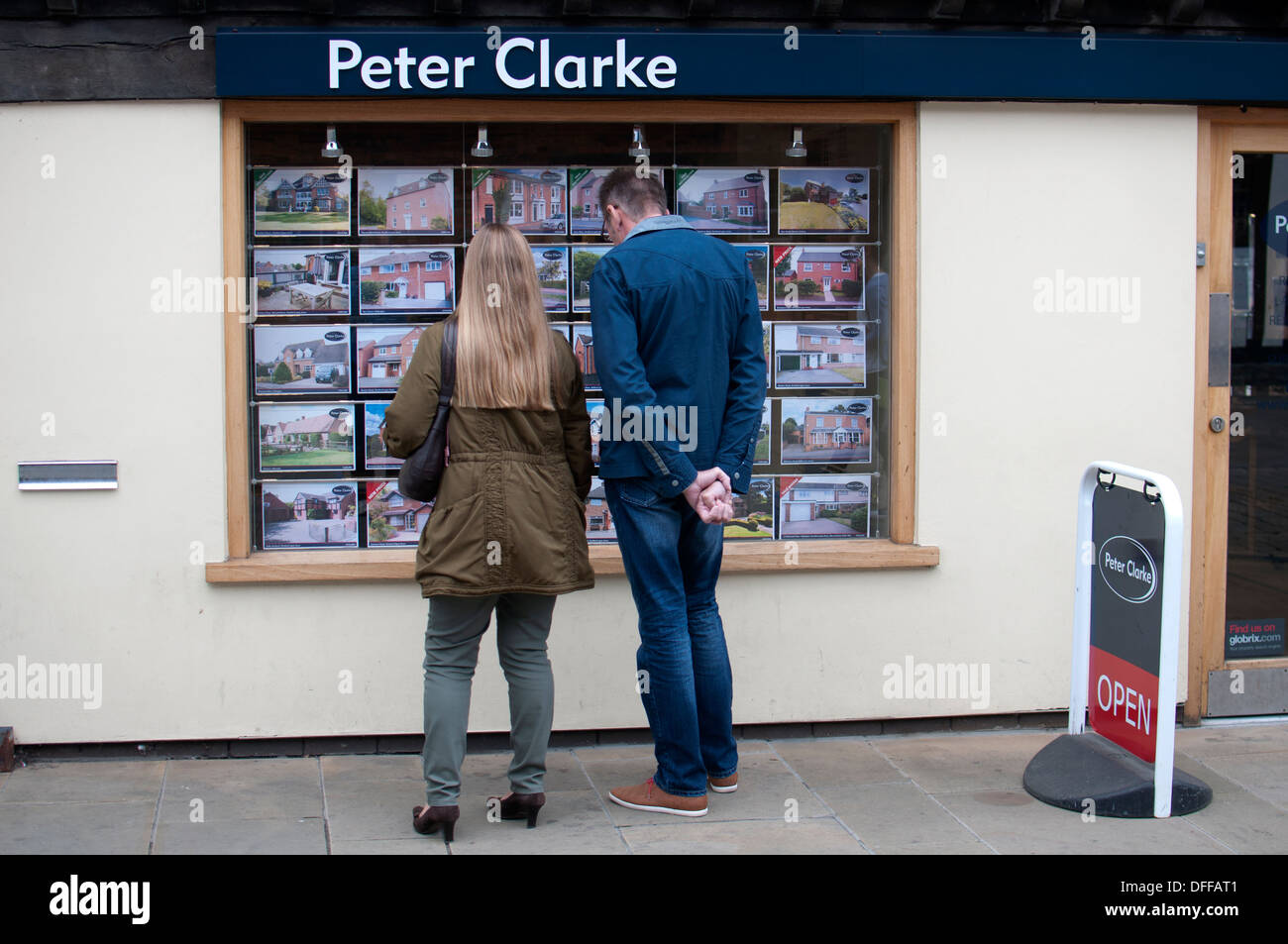 Couple looking in estate agents window Stock Photo