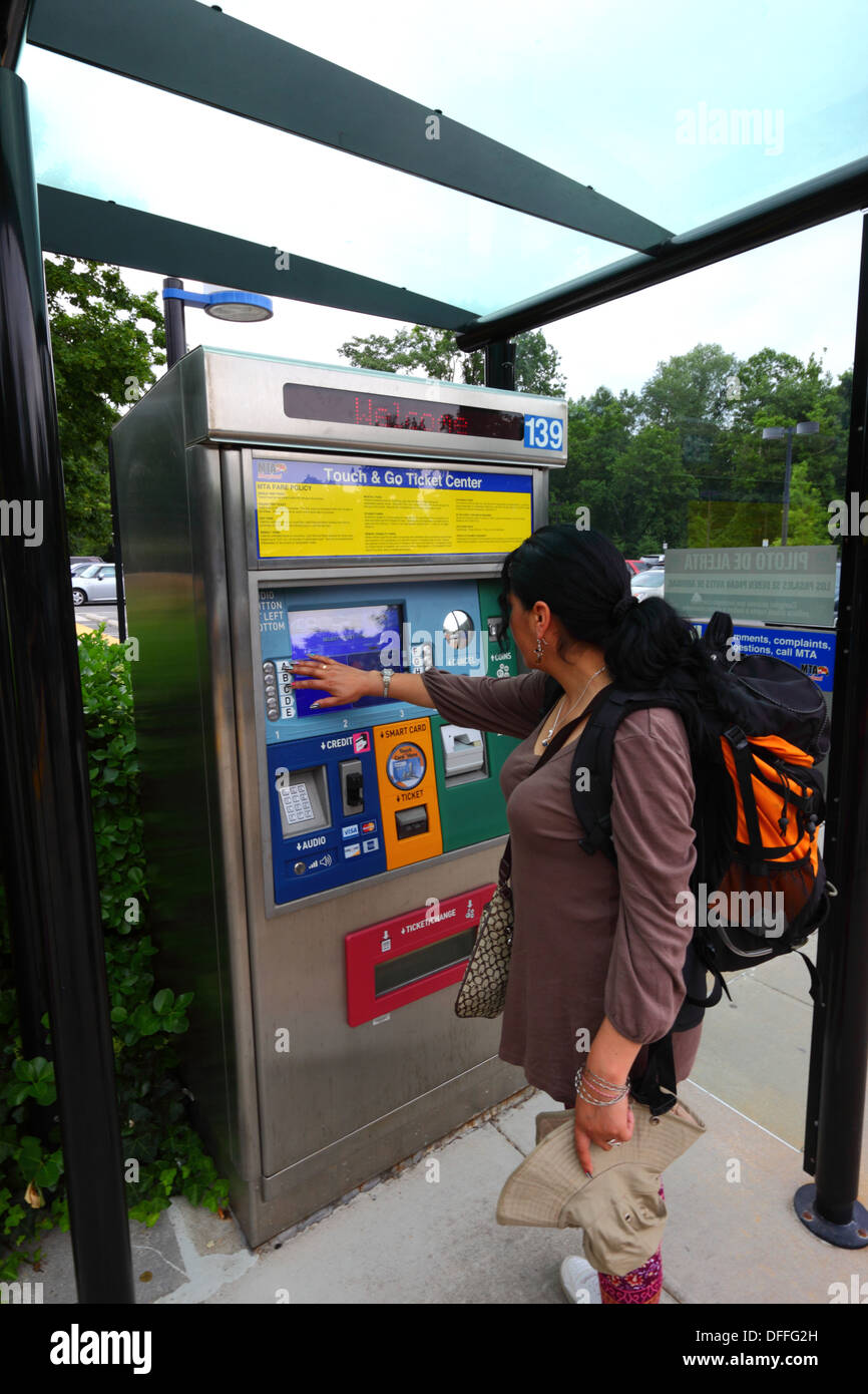 Hispanic girl buying a ticket using an automated ticket vending machine with touchscreen, Falls Road Light Rail Stop, Baltimore County, Maryland, USA Stock Photo