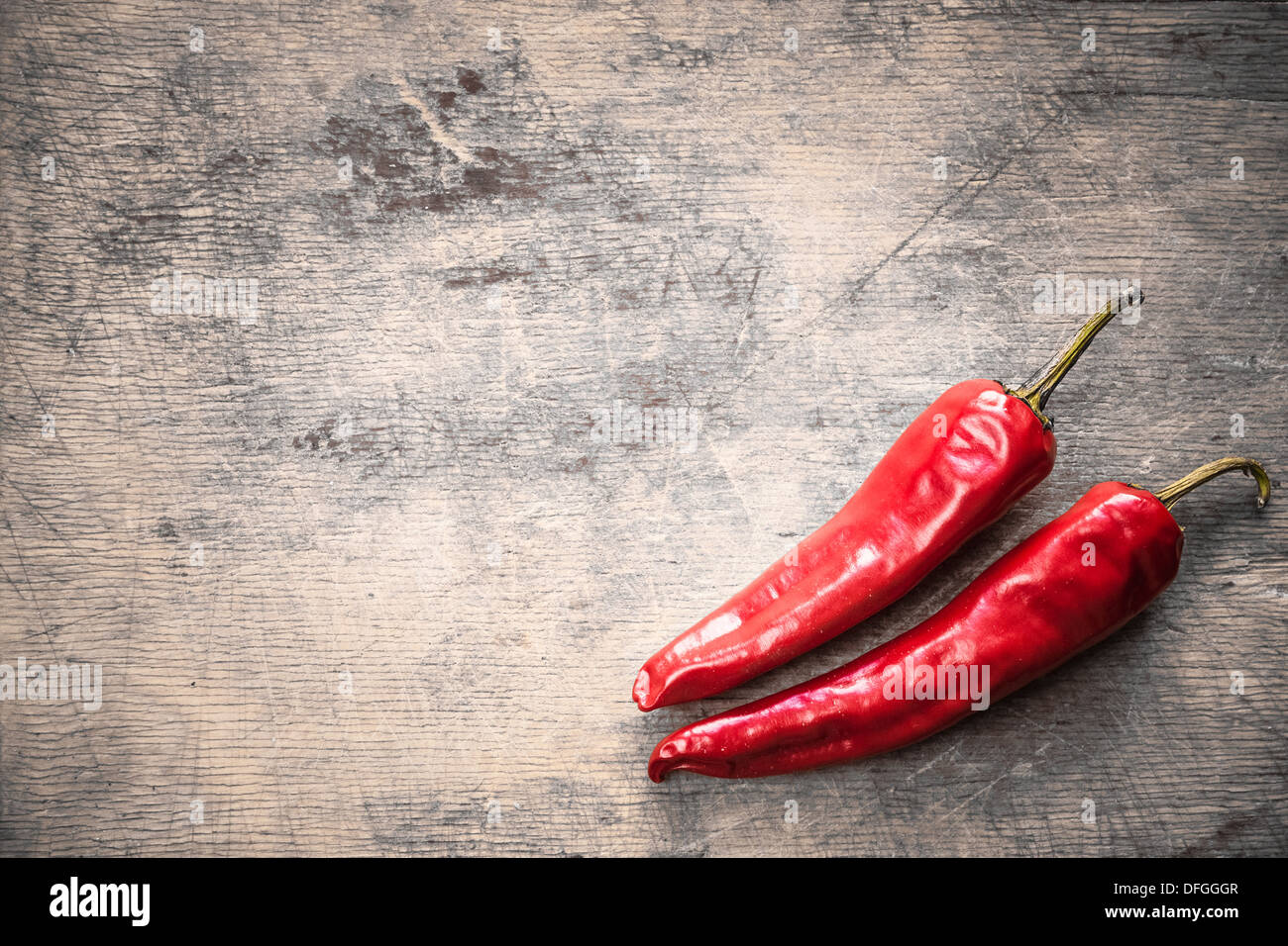 Red hot chili peppers on old wooden table surface texture background ...