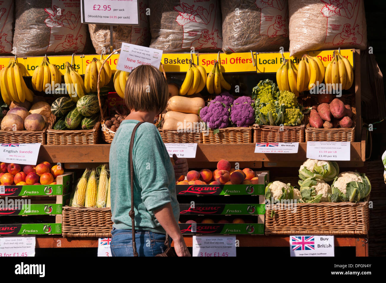 Housewife Browsing Outside A greengrocers Fruit and Veg Shop Display UK Stock Photo