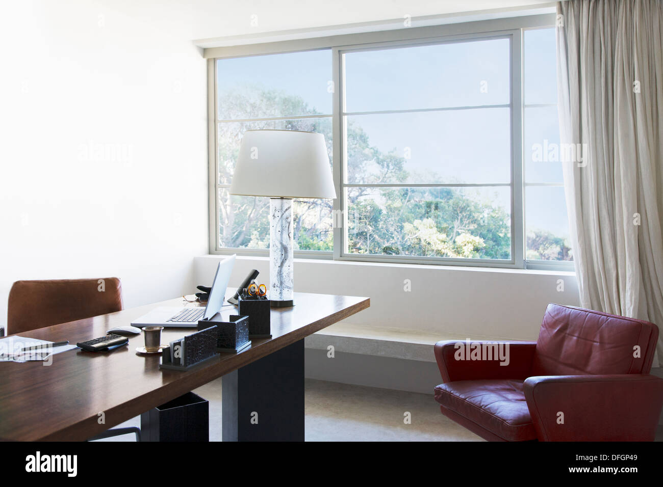 Laptop and lamp on desk in office Stock Photo