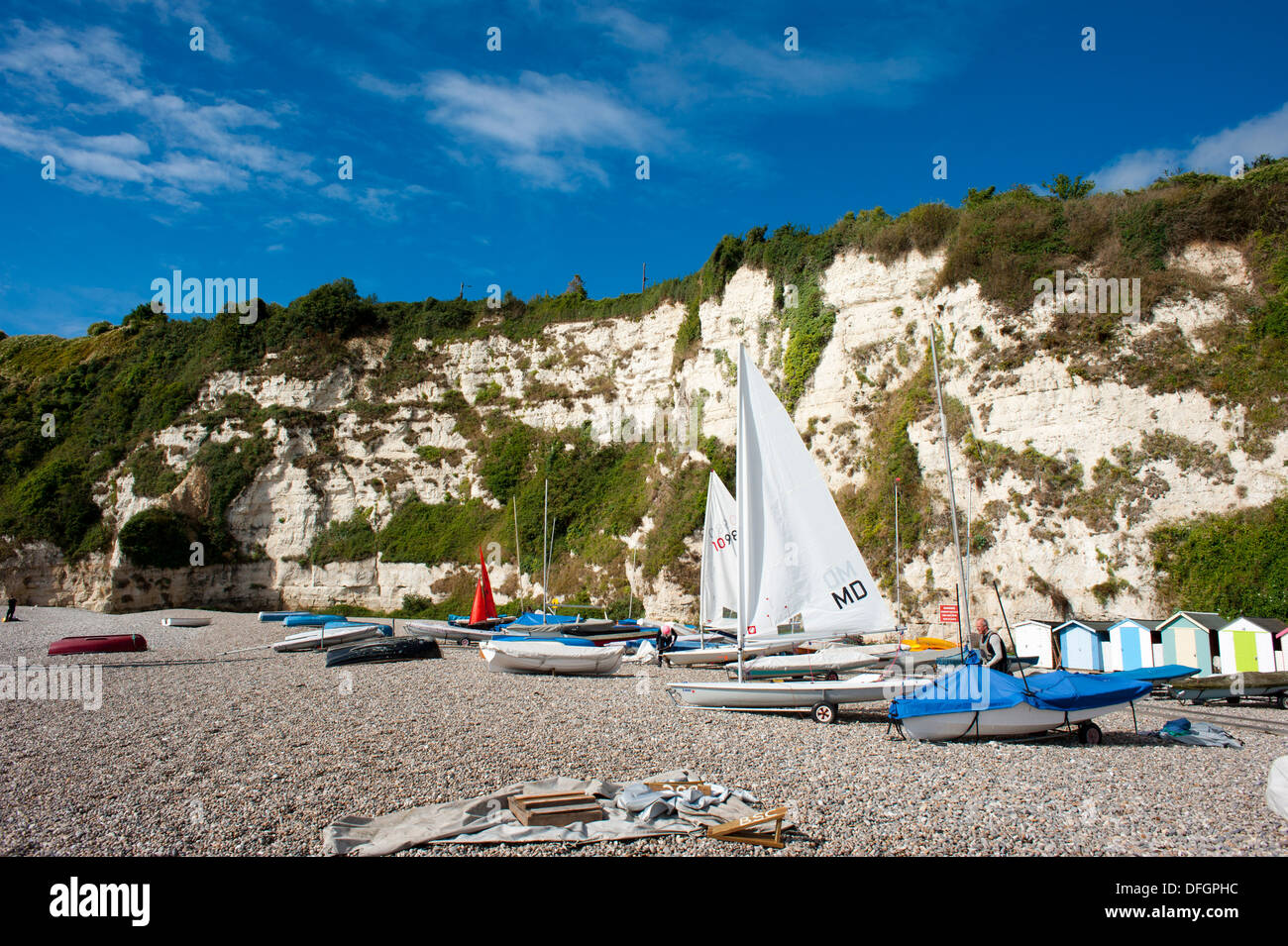 Sailing boats on shingle beach under white cliffs at Beer Devon England UK Stock Photo