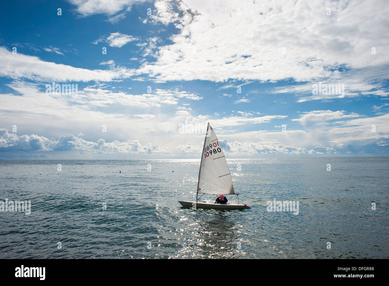 Sailing dinghy in sunshine on the sea at Beer Devon England Stock Photo