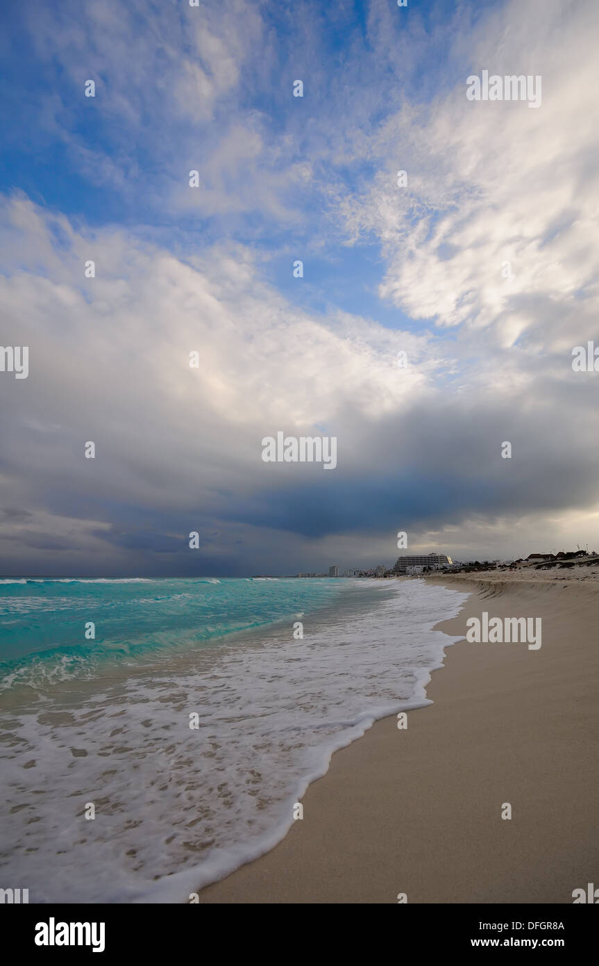 Turquoise waves turn to foamy surf on sandy beach Stock Photo