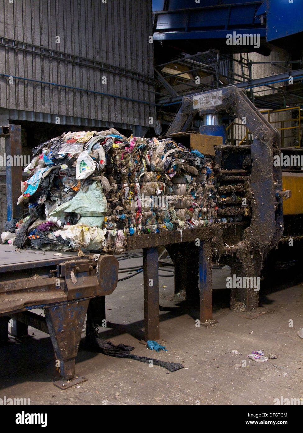 Bale of waste plastic on hydraulic press in recycling plant. The plastic is separated from household waste Stock Photo