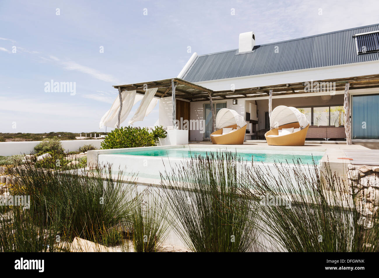 Swimming pool, chairs and patio of modern house Stock Photo