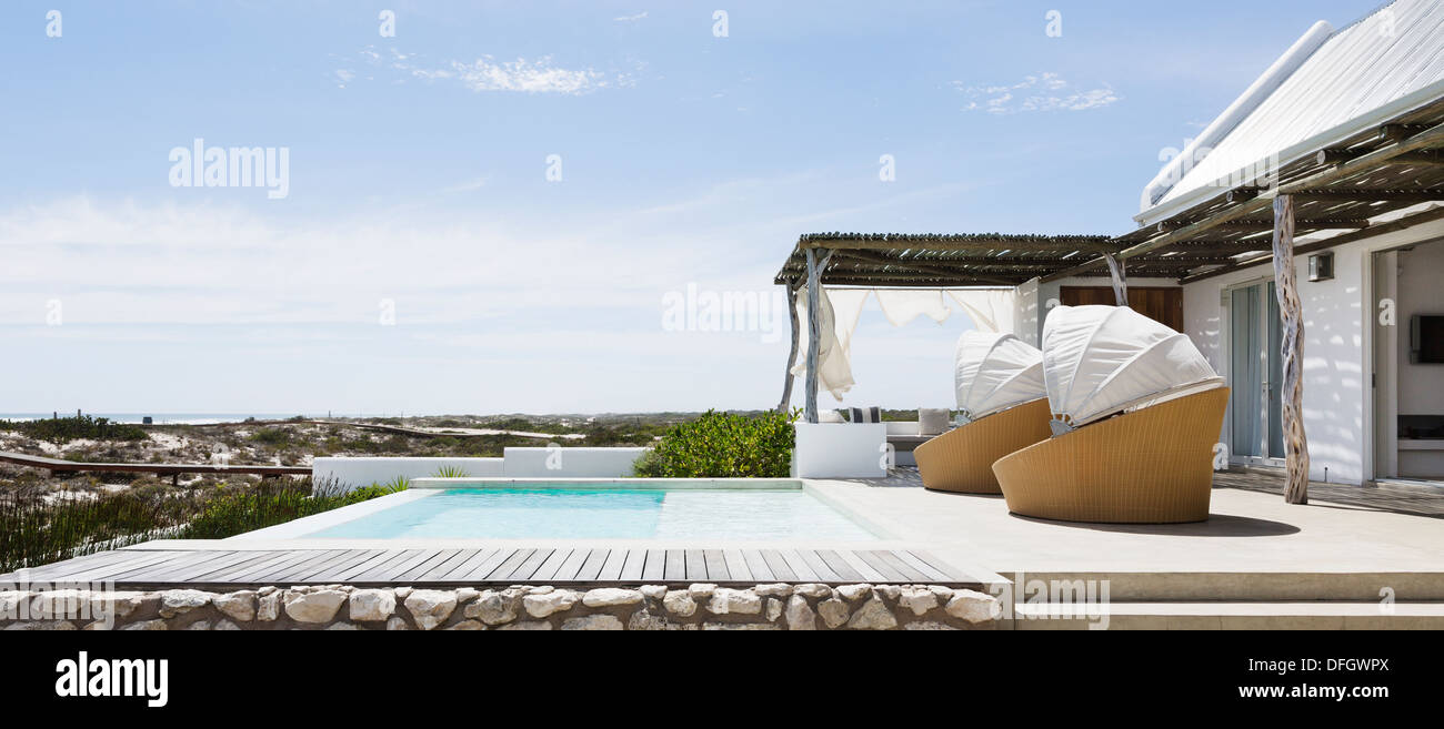 Swimming pool, chairs and patio of modern house Stock Photo