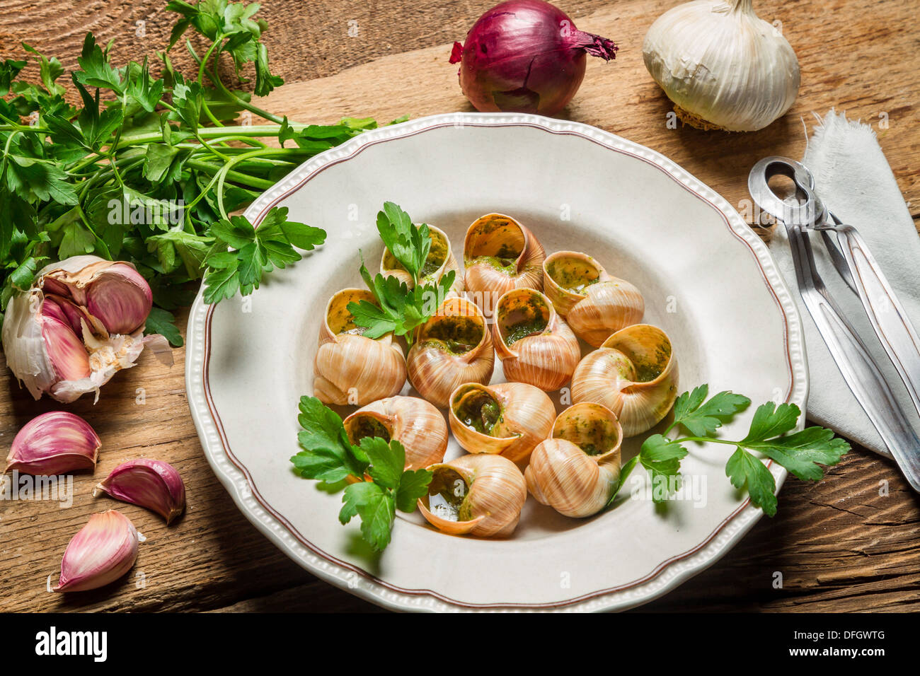 Homemade baked snails with garlic butter and fresh herbs Stock Photo