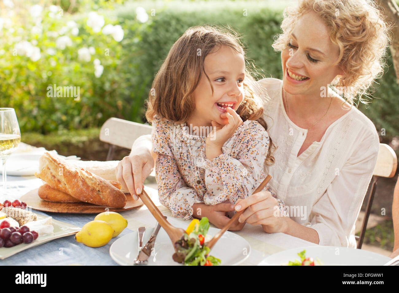 Mother and daughter eating in garden Stock Photo