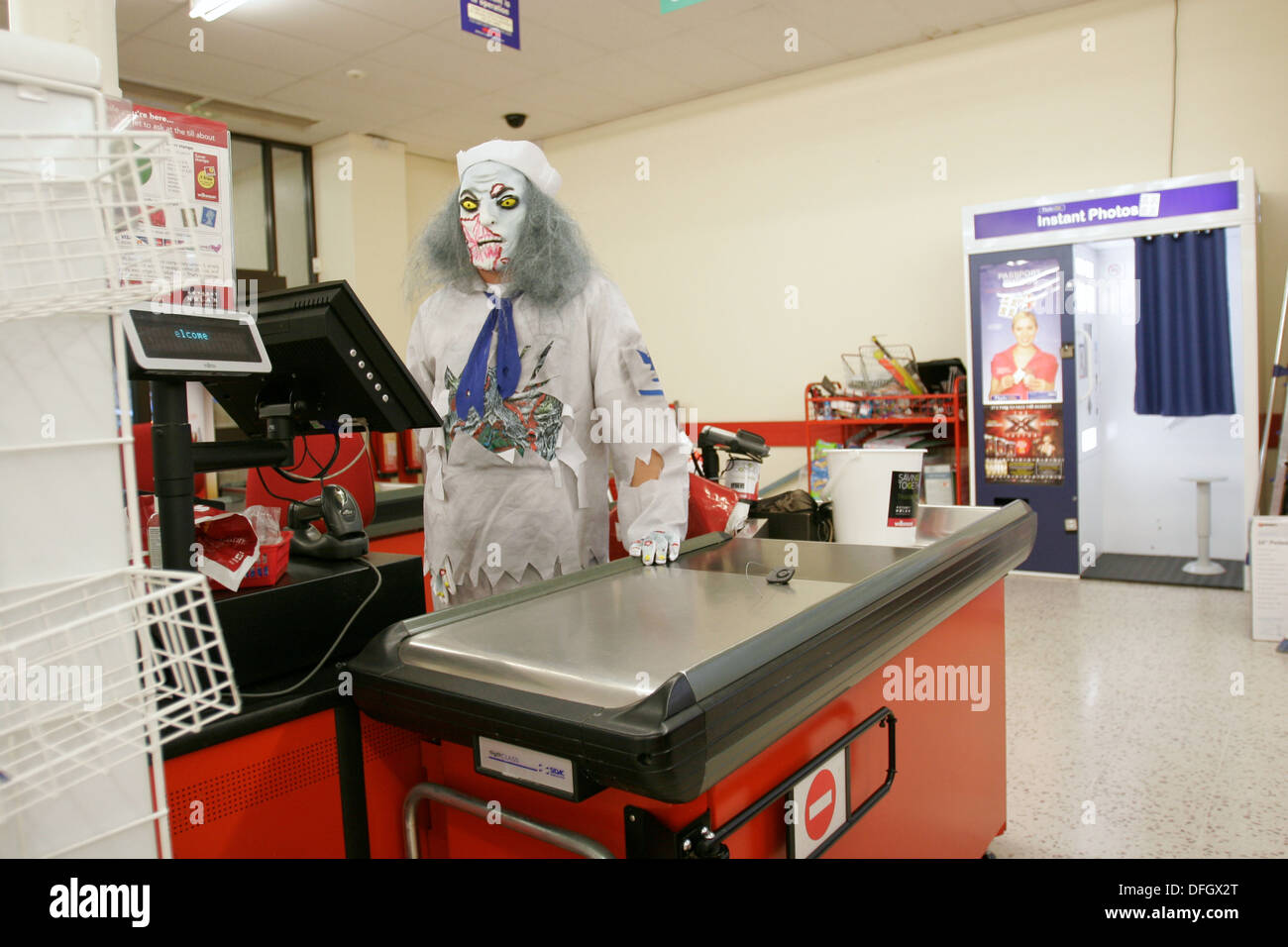 Supermarket cashier wearing a fancy dress costume for Halloween. UK Stock Photo