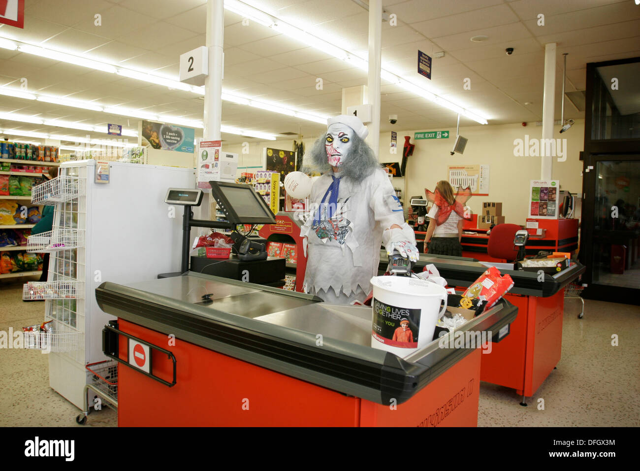 Supermarket cashier wearing a fancy dress costume for Halloween. UK Stock Photo