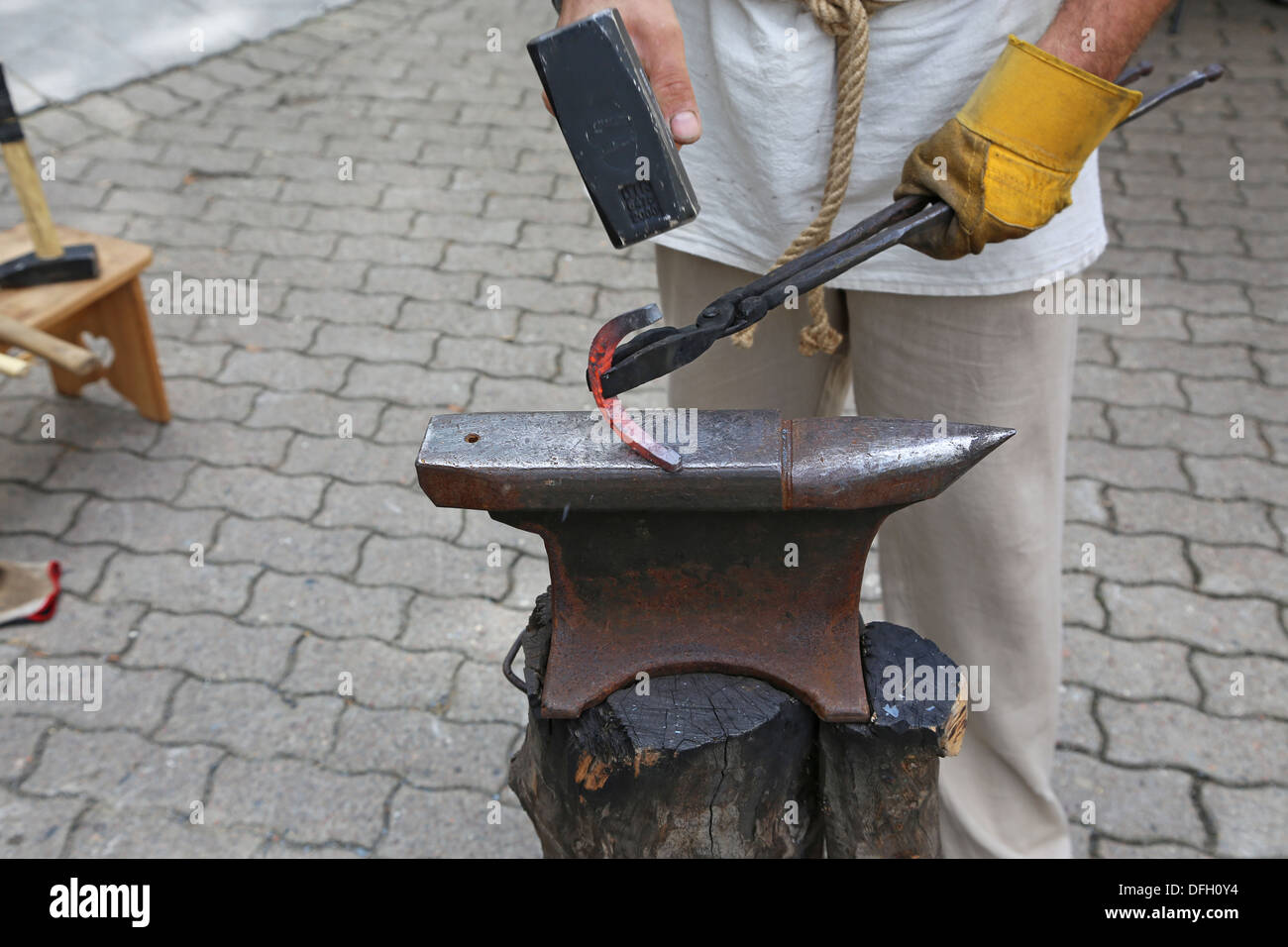 Blacksmith forges a hot shoe on the anvil Stock Photo
