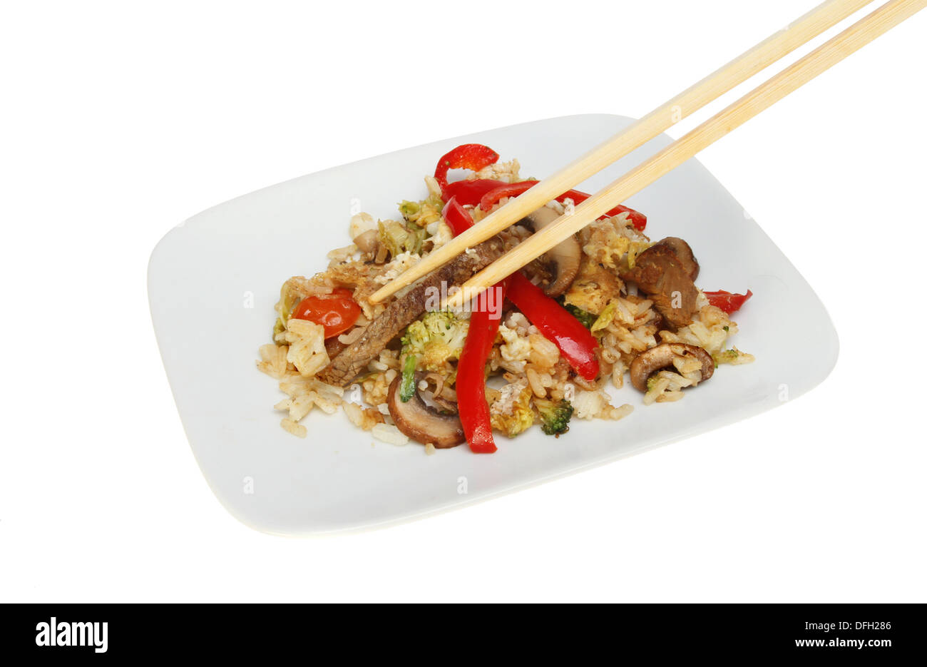 Beef and vegetable stir fry on a plate with chopsticks isolated against white Stock Photo