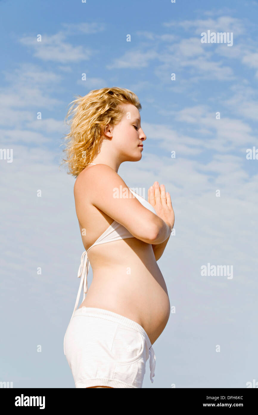 Blonde pregnant woman doing yoga at the beach Stock Photo - Alamy