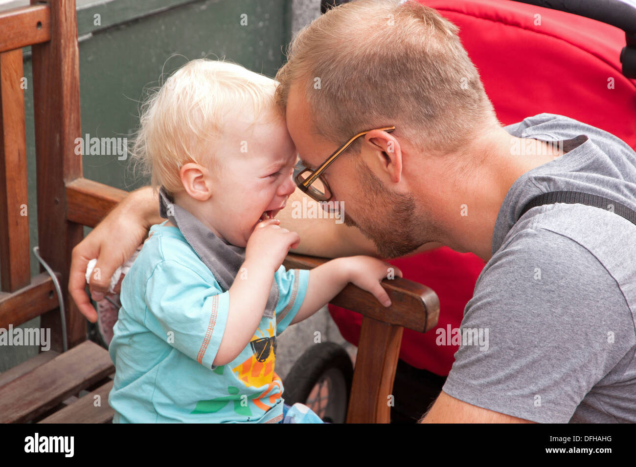 Crying child being comforted and calmed by his father. Stock Photo