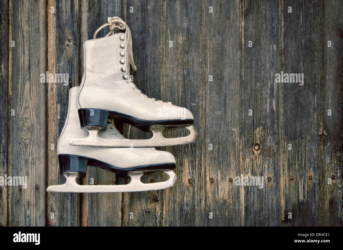 Old ice skates hanging on rustic wooden wall Stock Photo - Alamy