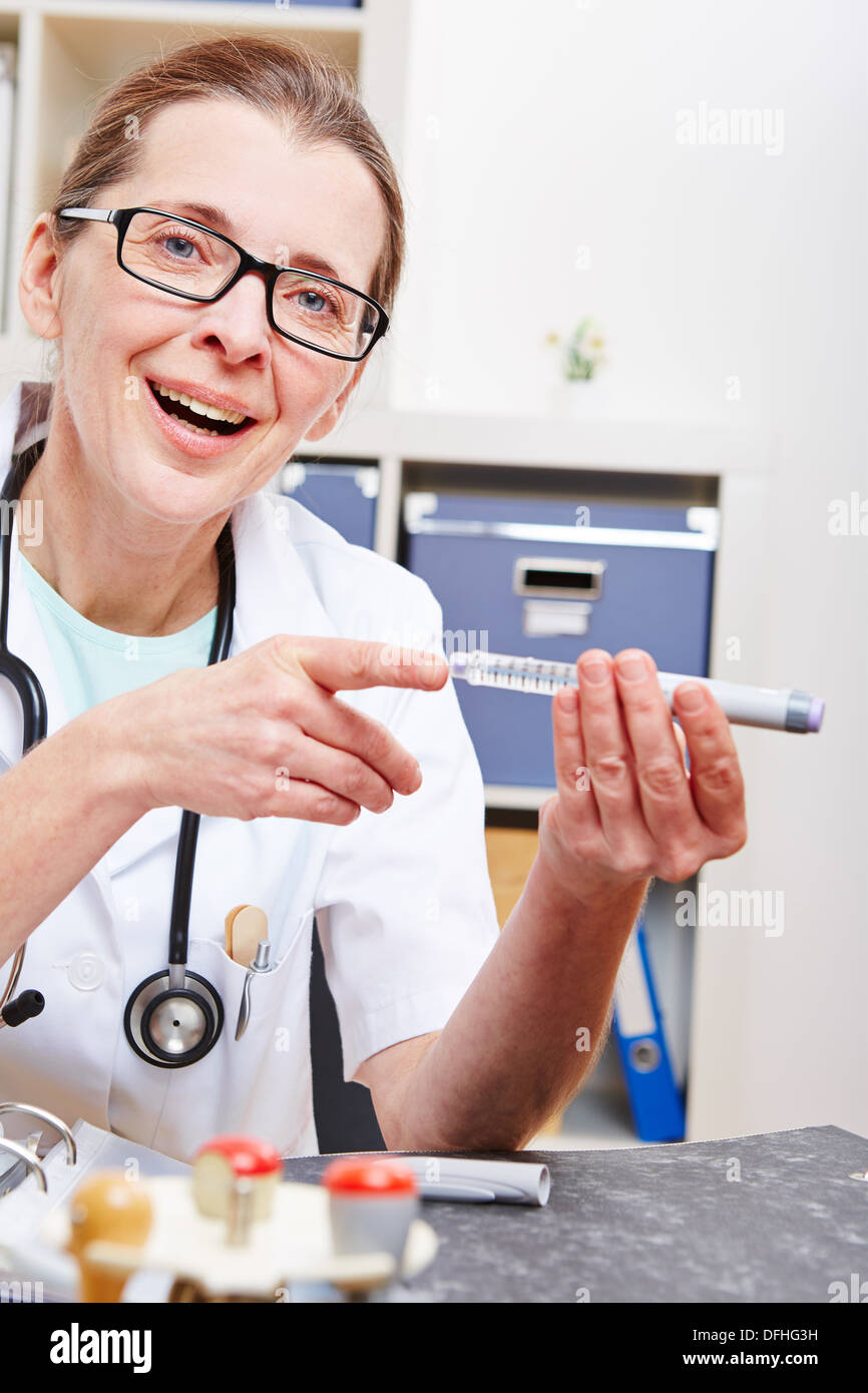 Senior doctor explaining syringe for insulin injection in her office