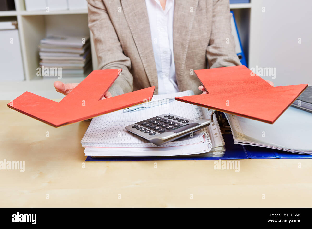 Two red arrows in the office beind held by business woman Stock Photo ...