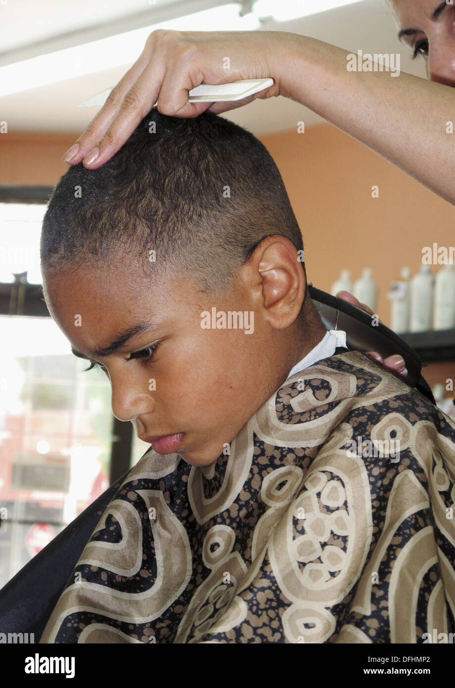 6 year old african american boy getting a hair cut making a