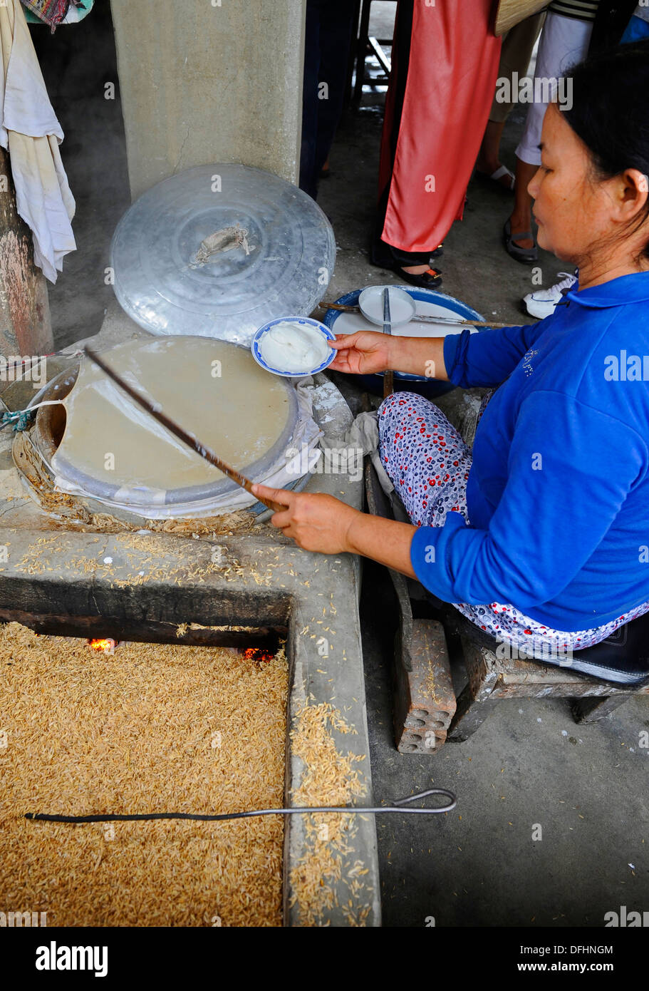 Vietnamese village woman making noodles over a rice fueled stove. Stock Photo