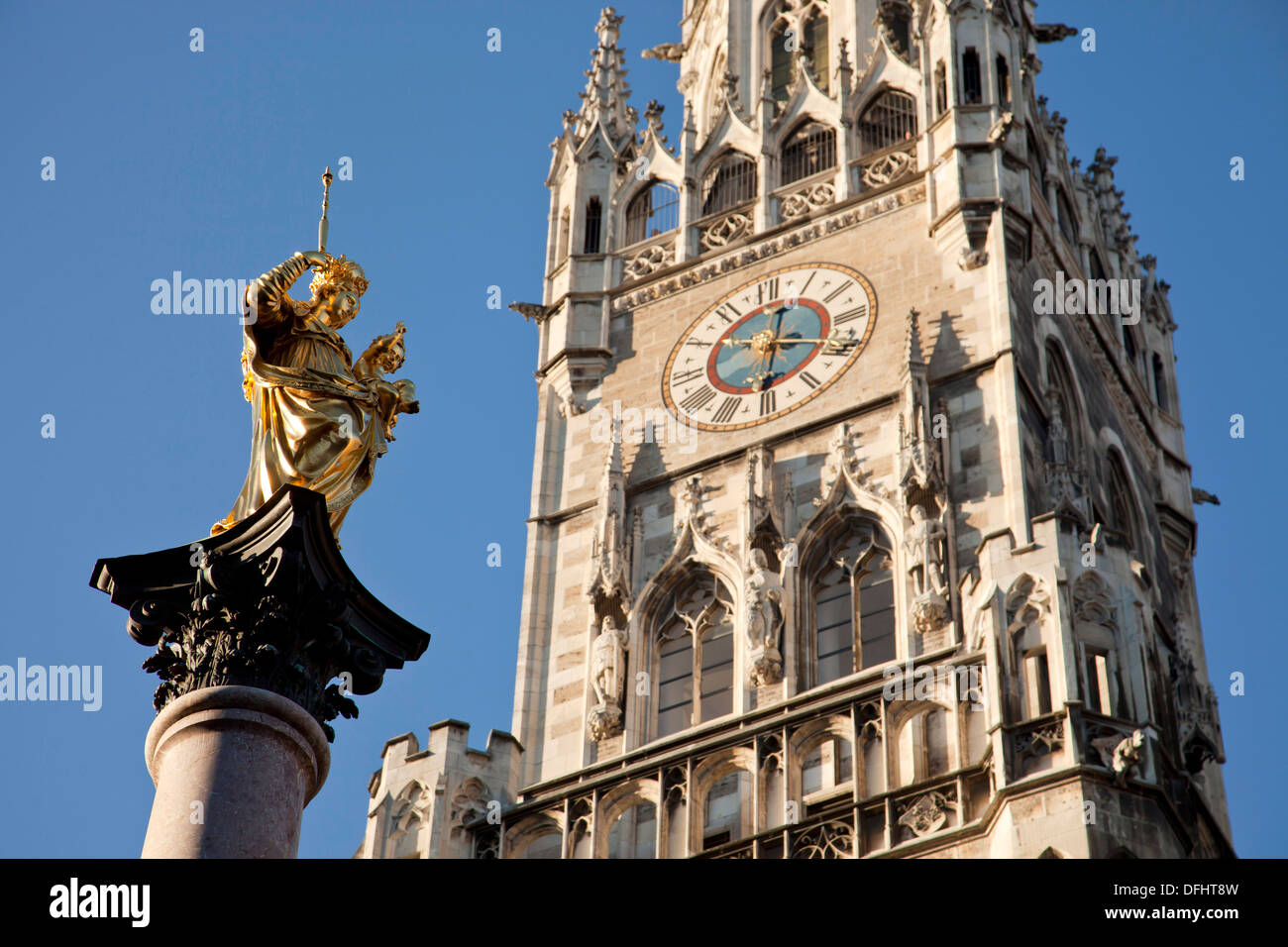 Virgin Mary atop the Mariensäule and the new townhall Neues Rathaus on the central square Marienplatz in Munich, Bavaria, German Stock Photo
