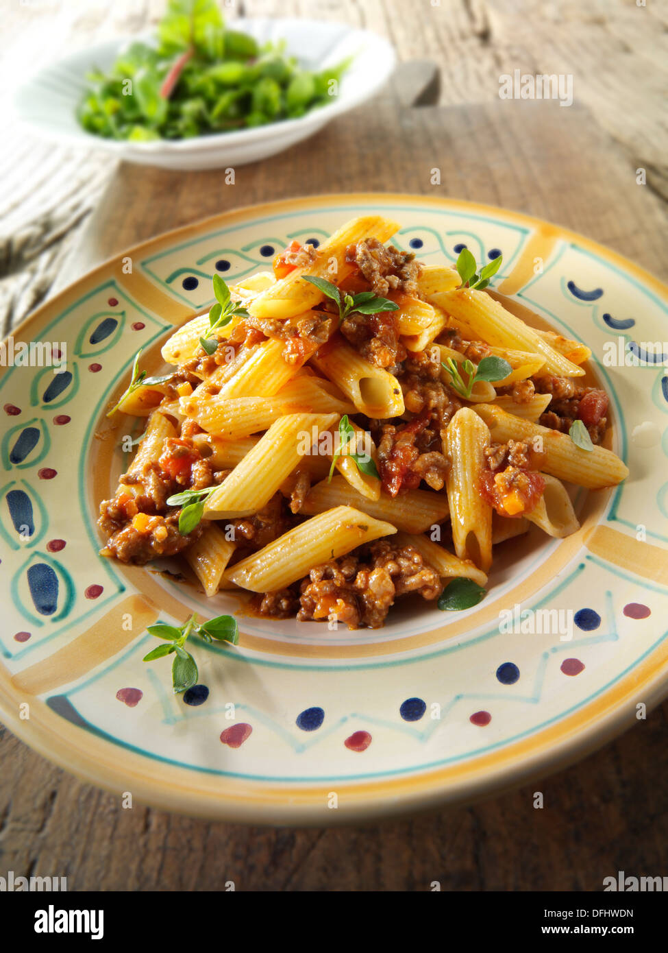 Fresh cooked pene and bolognese ragout served on a plate in a table ...
